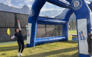 A tennis player practicing their serve on the Tennis Alberta Smash Tent